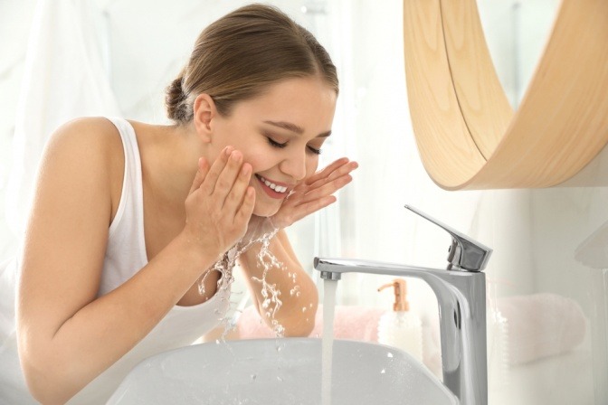 Frau wäscht ihr Gesicht mit Seife