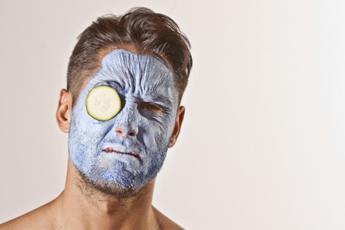 Ein Mann mit einer blauen Gesichtsmaske sieht unglücklich aus
