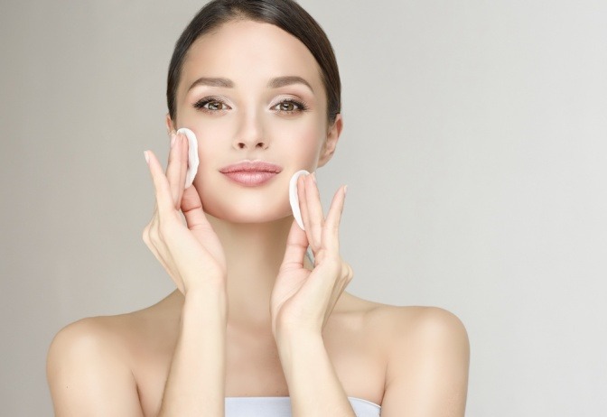 Frau cremt ihr Gesicht mit Naturkosmetik ein
