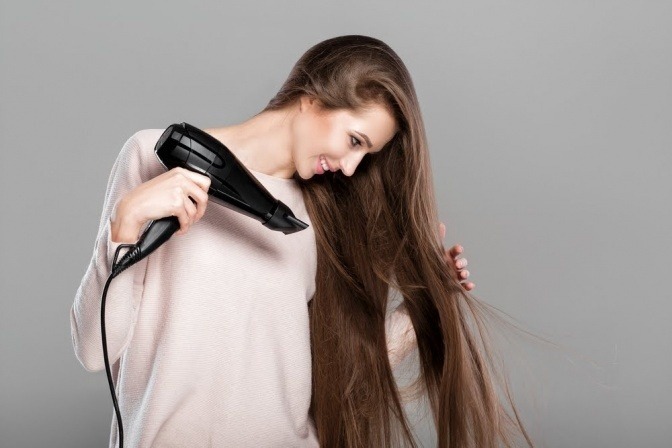 Eine Frau föhnt ihre glatten Haare