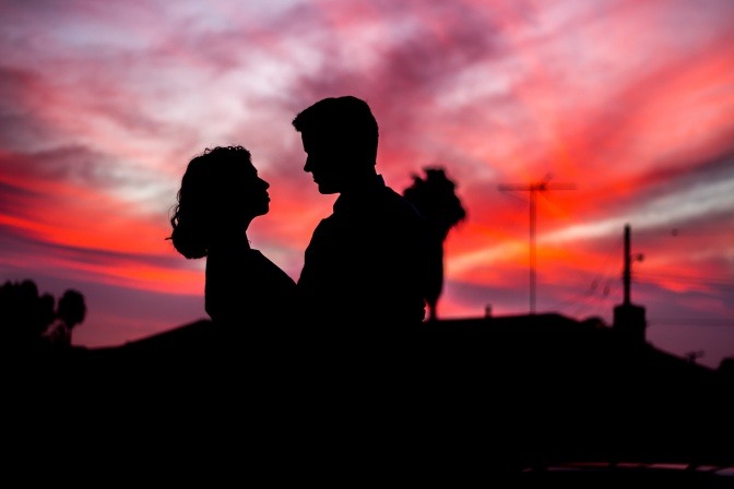 Ein Paar umarmt sich vor dem Hintergrund eines Sonnenuntergangs.