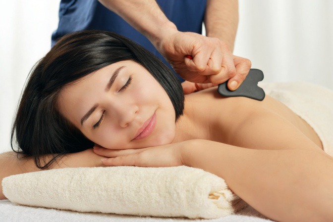 Eine Frau bekommt eine Gua Sha Massage