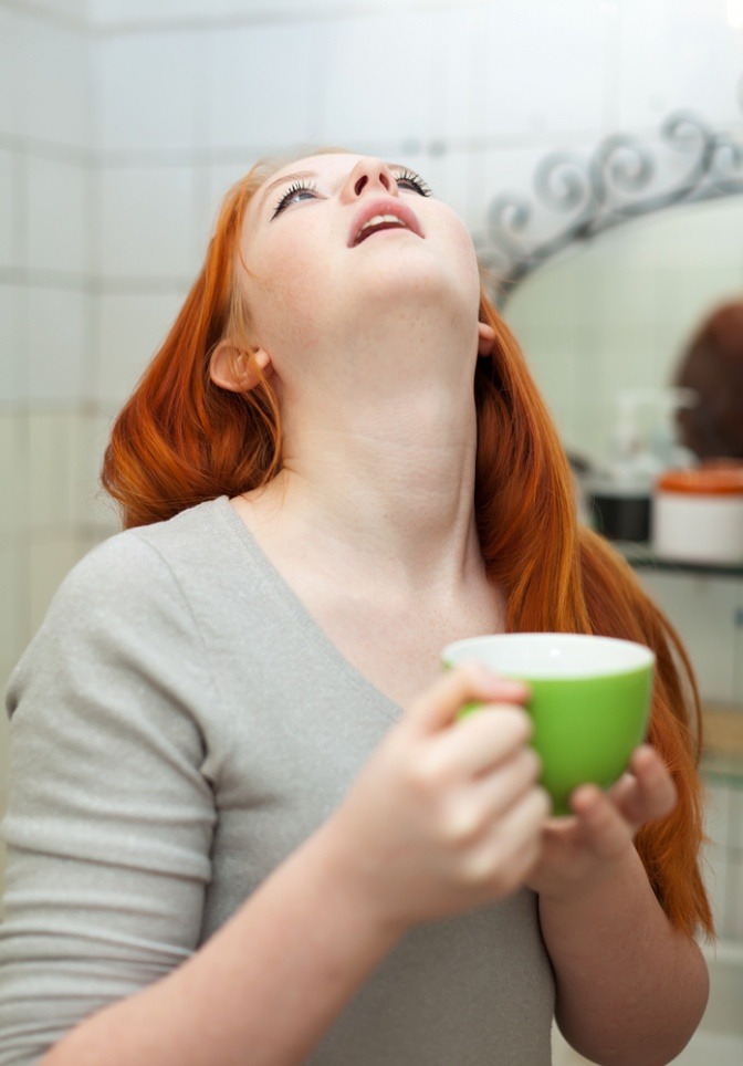 Eine Frau gurgelt gegen Schnarchen, am besten mit Pfefferminze