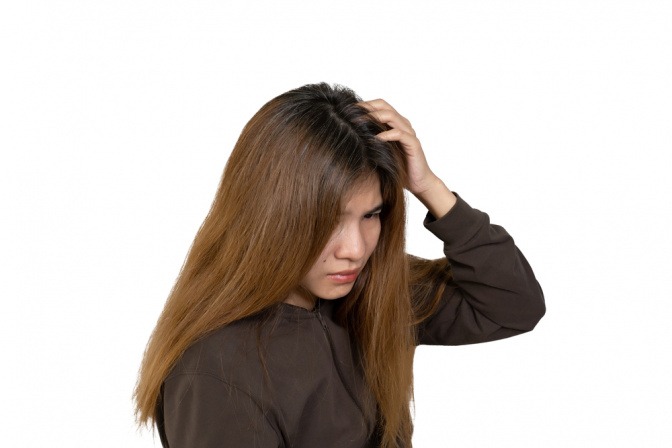 Junge Frau mit langen Haaren und rauswachsendem Haaransatz