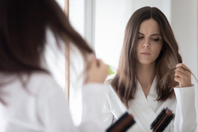 Frau betrachtet skeptisch ihre Haare