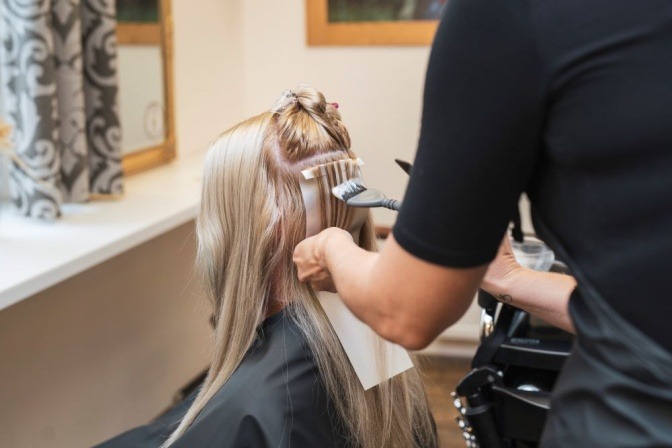 Friseurin färbt Haare einer Frau