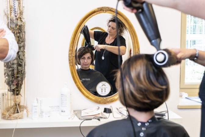 Frau bekommt Haare geföhnt im Zuge einer Kopfhautsanierung