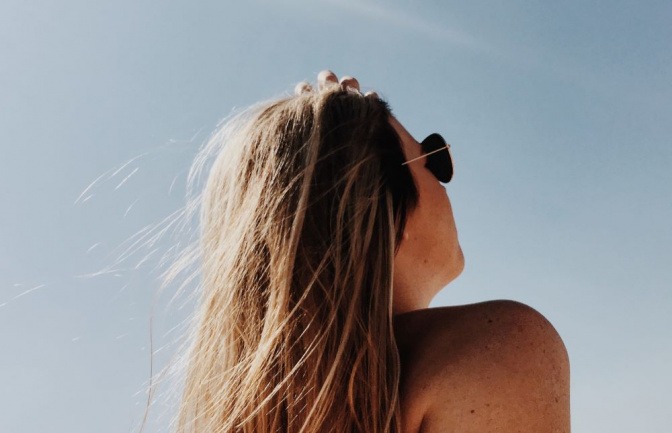 Eine Frau steht im Freien und die Sonne scheint auf die Haare