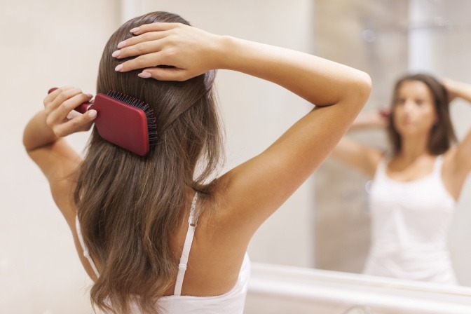 Eine Frau pflegt die Haare mit einer Bürste