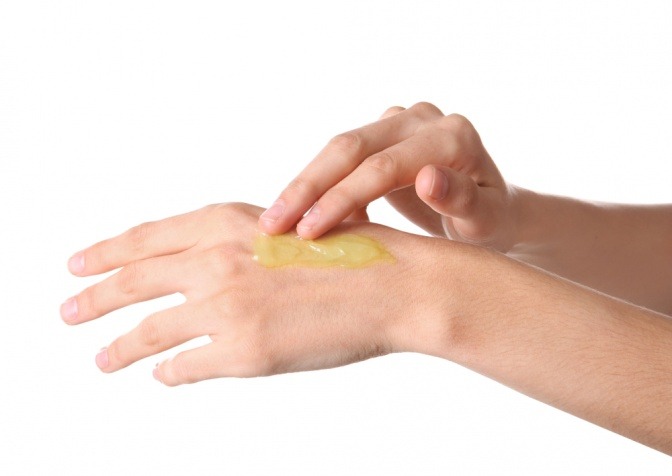 CBD Öl Wirkung auf die Haut: Eine Frau verreibt sich CBD Öl auf dem Handrücken. 