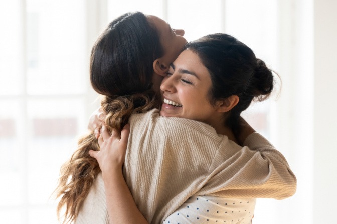 Zwei Frauen mit offenem Herz-Chakra umarmen sich