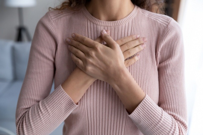 Eine Frau hält ihre Hände aufs Herzchakra für die Herz-Kopf Kohärenz