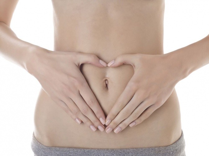 Eine Frau formt mit ihren Händen ein Herz vor ihrem Bauch