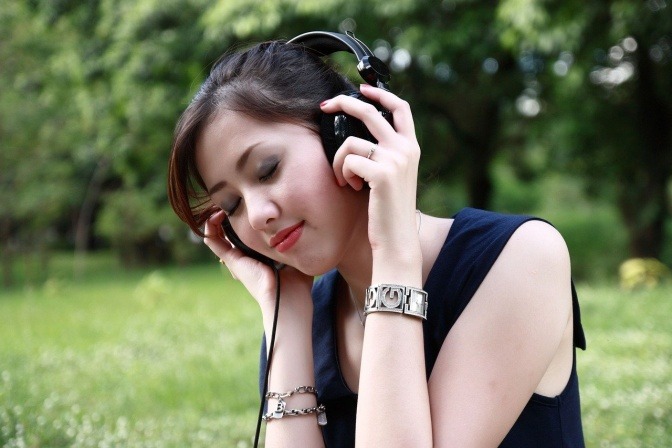 Eine Frau hört Musik und lächelt.