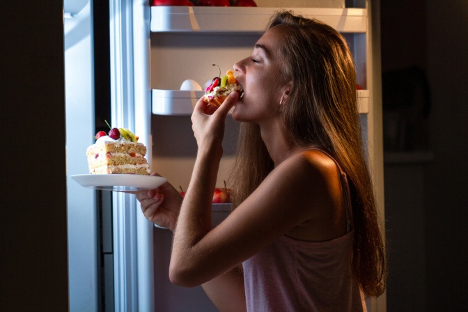 Frau vor dem Kühlschrank