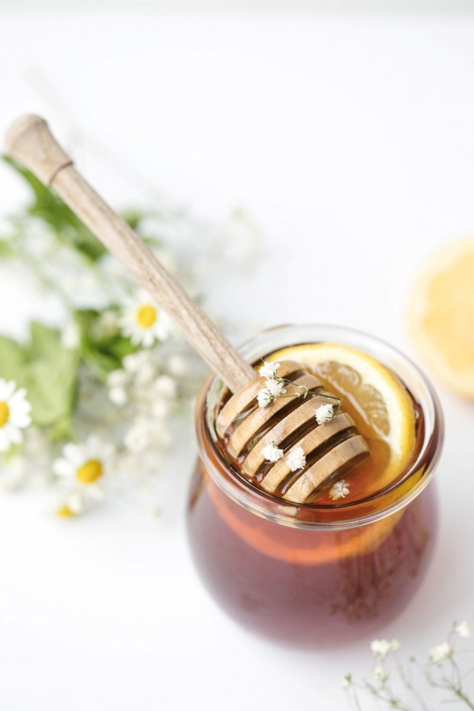 Auf Honig liegen Blüten einer Kamille