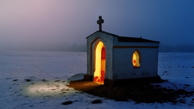 In einer Kapelle im dunklen Winter brennt Licht