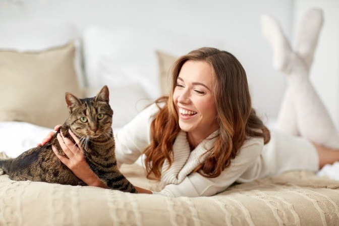 Frau mit Katze im Bett