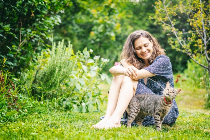 Frau mit Katze auf einer Wiese