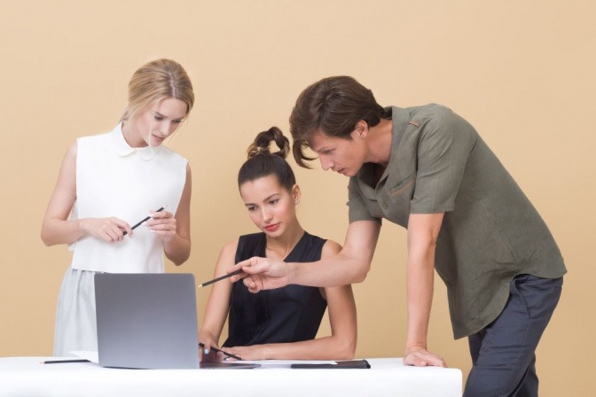 Zwei Frauen und ein Mann sind für ein Büro gekleidet