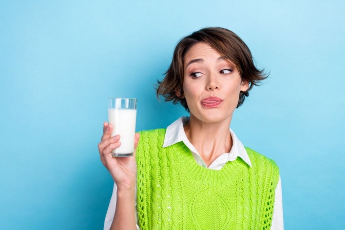 Frau mit einem Glas Milch gegen Knoblauchgeruch