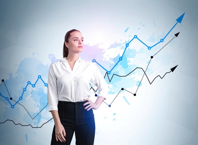 Frau in Business-Anzug mit zuversichtlichem Blick, Hand auf Taille, steigende blaue und schwarze Pfeile auf blauem bunten Hintergrund.
