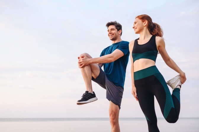 Frau und Mann beim Dehnen nach dem Sport
