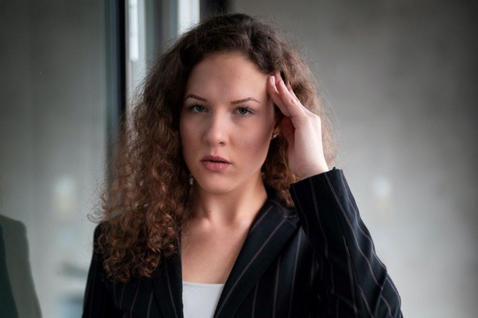 Eine Frau fasst sich an die schmerzenden Schläfen.