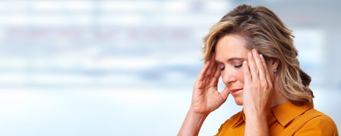 Eine Frau massiert den Kopf gegen Kopfschmerzen
