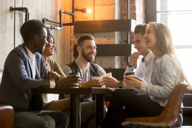 Gruppe von Menschen in einem Cafe bei einem anregenden Gruppengespräch.