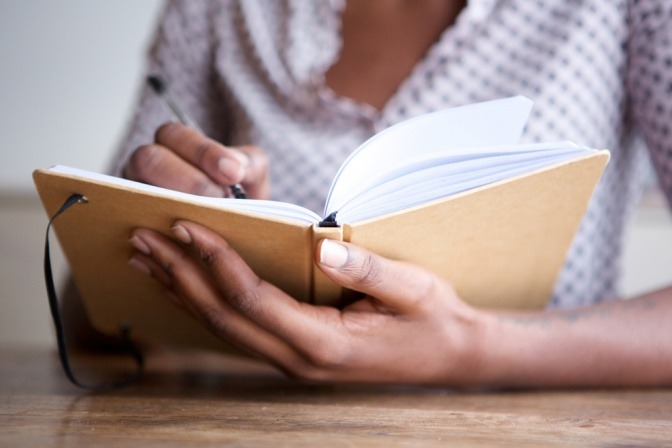 Frau schreibt in ein Buch