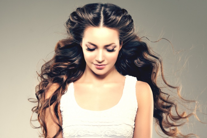 Eine Frau mit gewellten langen braunen Haaren