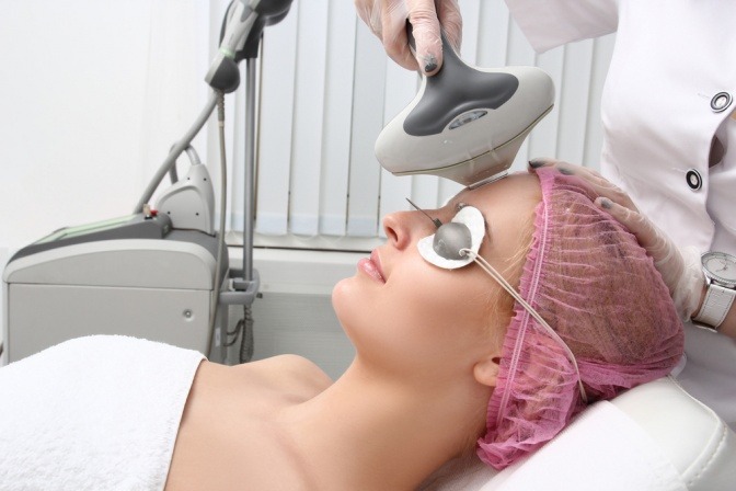Eine Frau wird mit einem Laser im Gesicht behandelt