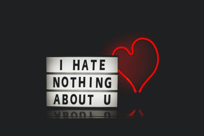 Der Schriftzug "I hate nothing about you" neben einem leuchtenden roten Herz aus Neonröhren.