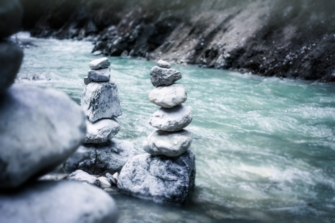 Steine sind in Balance neben einem Fluss