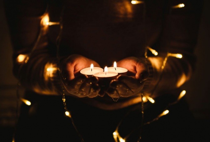 Flammen von Kerzen vertreiben mit ihrem Licht die Dunkelheit