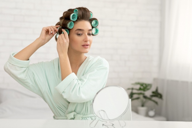 Junge Frau mit Lockenwickler im Haar