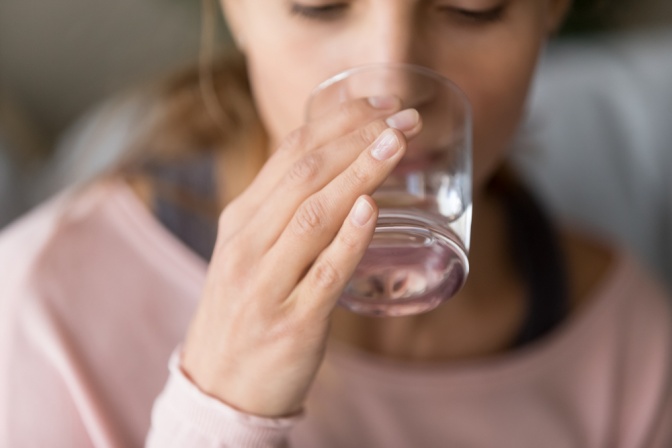 Frau trinkt Wasser mit Magnesium
