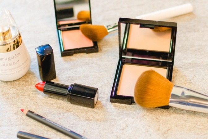 Auf einem Tisch stehen verschiedene Make-up-Utensilien