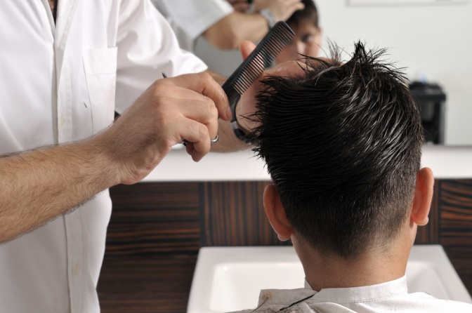 Ein Mann lässt sich beim Friseur die Haare schneiden