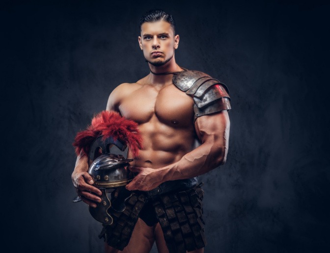 Ein muskulöser Mann in einem Gladiatorenoutfit.