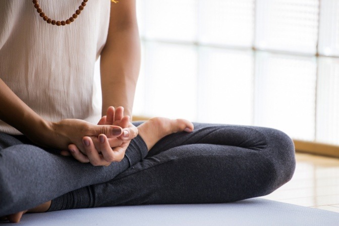 Frau meditiert auf Yoga Matte.