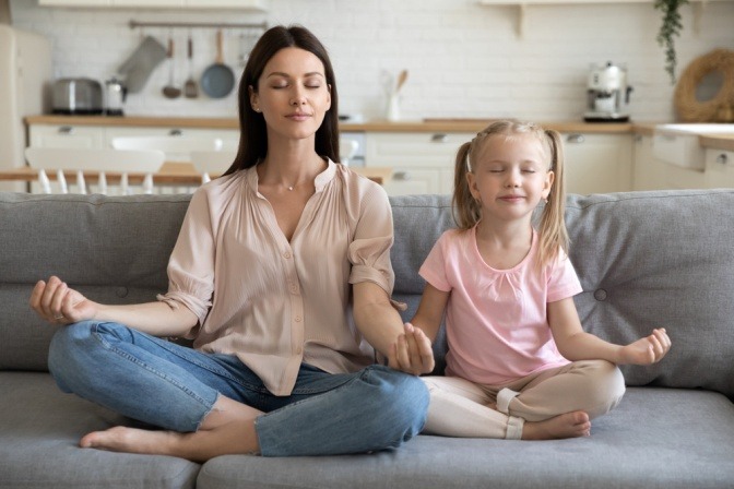 Frau und Mädchen meditieren als Entspannungstechnik
