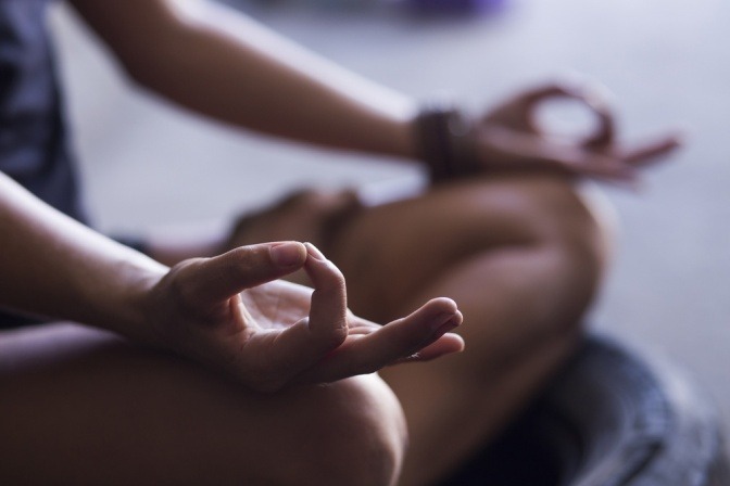 Eine Frau macht Mudras (Handübungen beim Yoga)