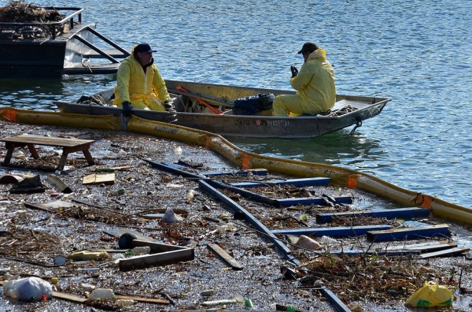 Zwei Männer sind in einem Boot im verschmutzten Meer