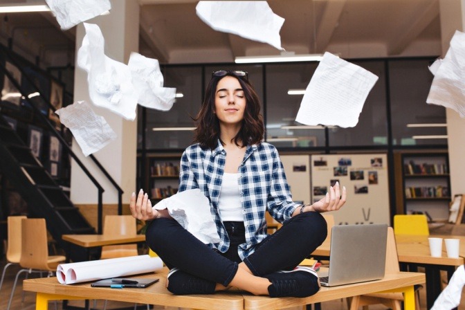Meditierenden Frau auf einem Büroschreibtisch