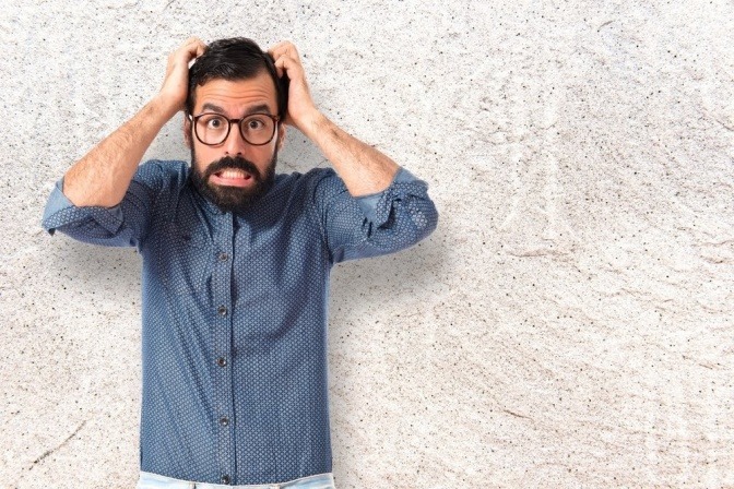 Ein frustrierter Mann rauft sich die Haare vom Kopf.