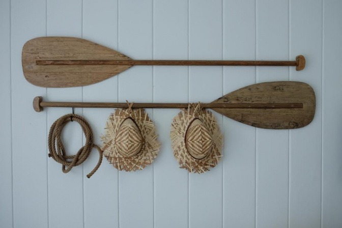 Zwei alte Bootspaddel wurden umfunktioniert und dienen nun als Garderobe an einer Wand. 