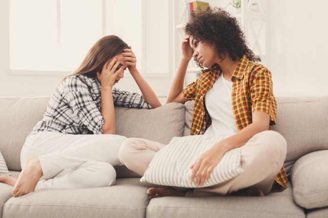 Zwei junge Frauen sitzen auf der Couch