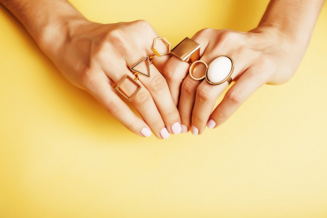 Modeschmuck-Ringe sind miteinander kombiniert auf einer Hand